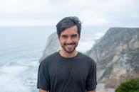 A Man in Black Shirt Smiling at the Camera