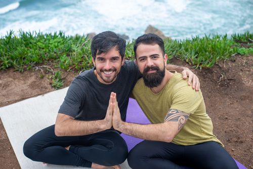 Free Two men enjoying a yoga session with a scenic ocean backdrop in Portugal. Stock Photo
