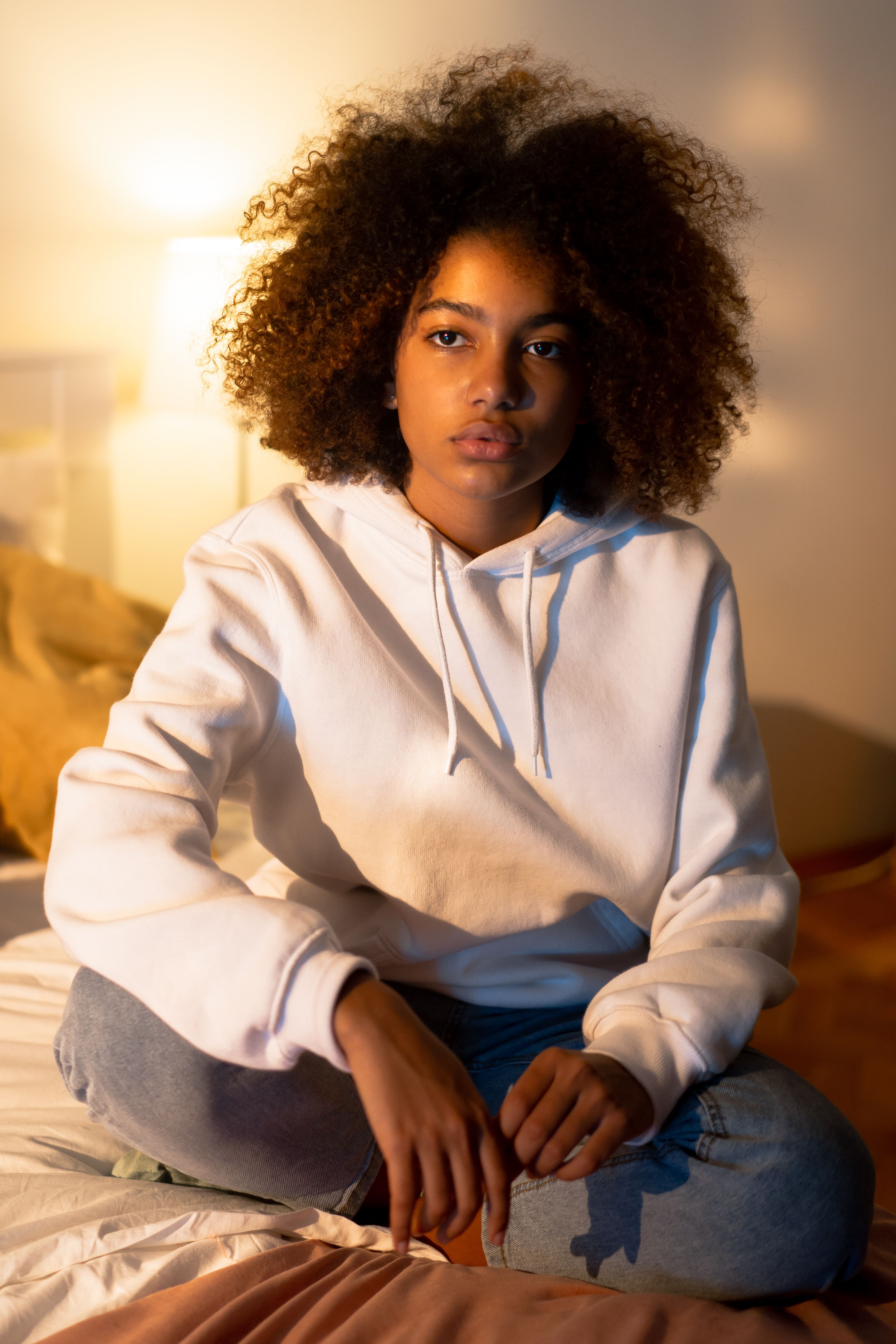 A Girl in White Sweatshirt Sitting on Bed · Free Stock Photo