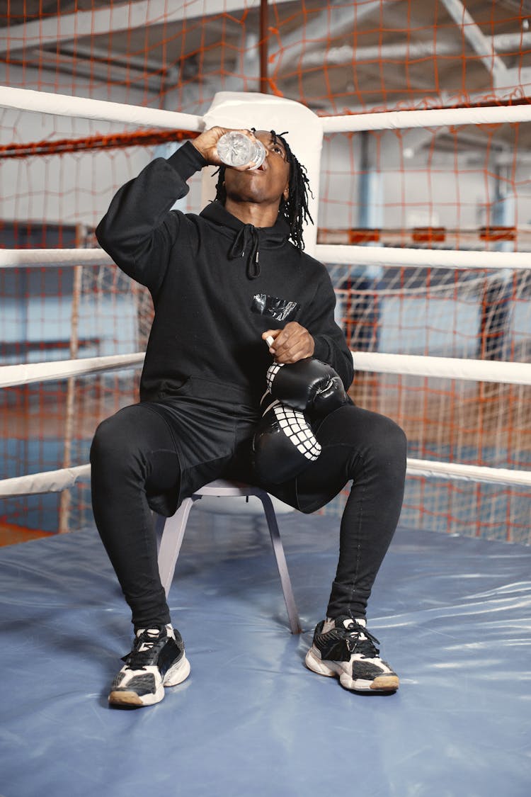 Man Drinking Water In Corner Of Boxing Ring