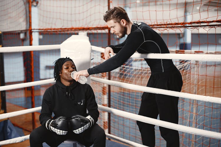 Trainer Giving Water To Drink To Sportsman