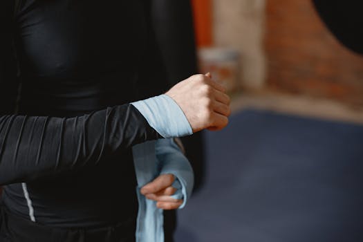 A man prepares for boxing by wrapping his hands with protection bandages.