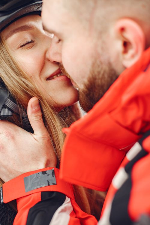 Free A close-up of a couple sharing a warm embrace and kiss, wearing winter jackets. Stock Photo