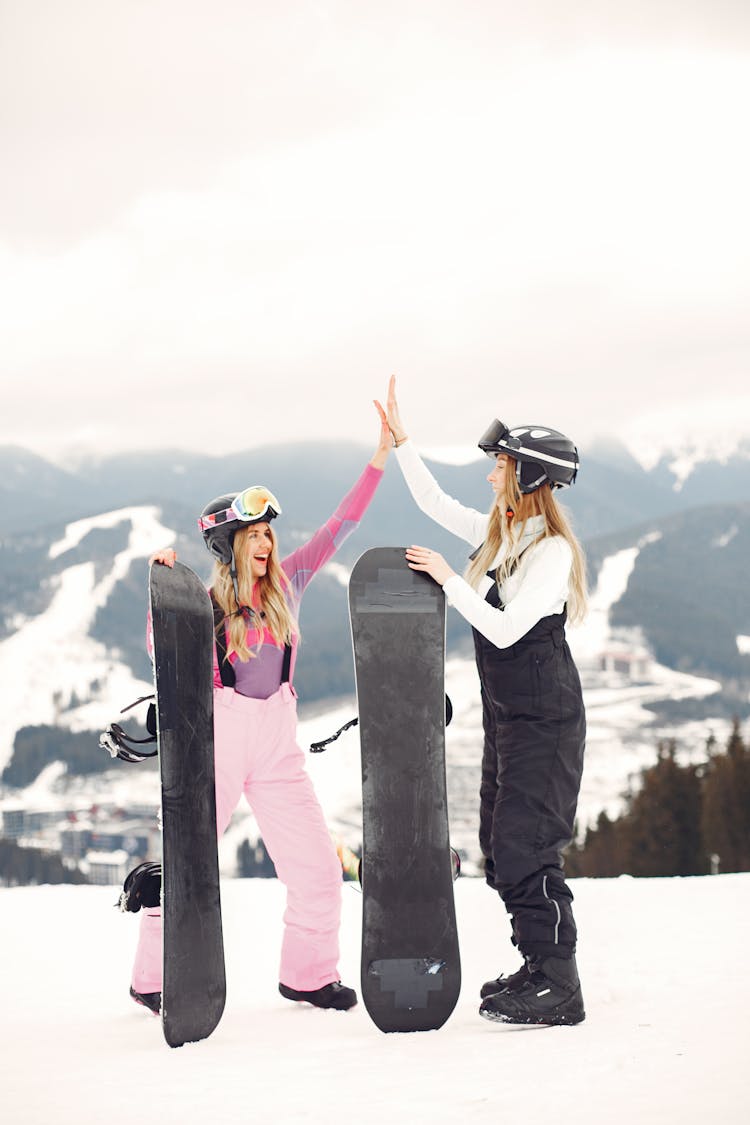 High Five Between Women With Snowboards