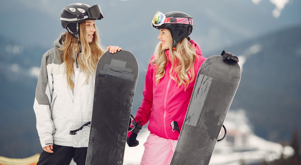 Zwei Snowboarderinnen auf einem verschneiten Berg