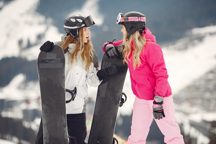 Women With Snowboards On Top Of Hill