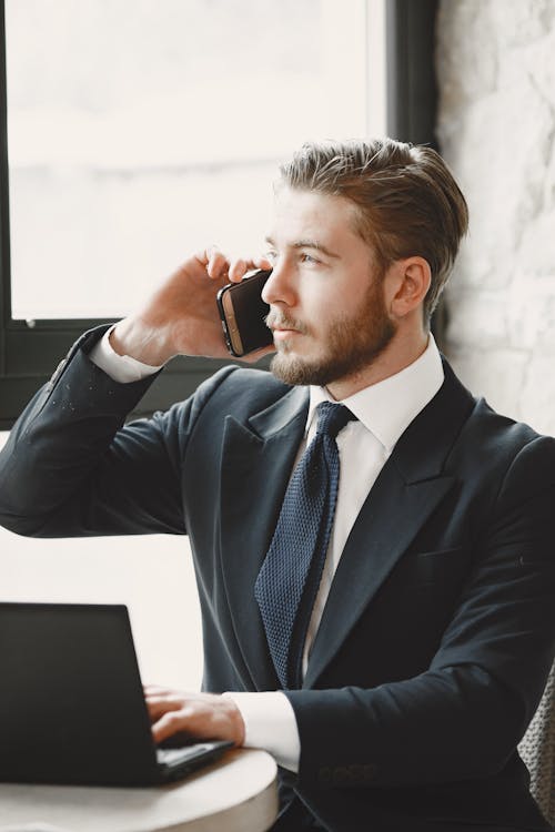 A Man Wearing a Suit Talking on a Phone