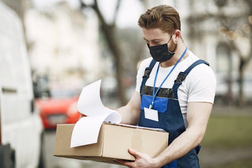 Deliveryman in Face Mask with Box Outdoors