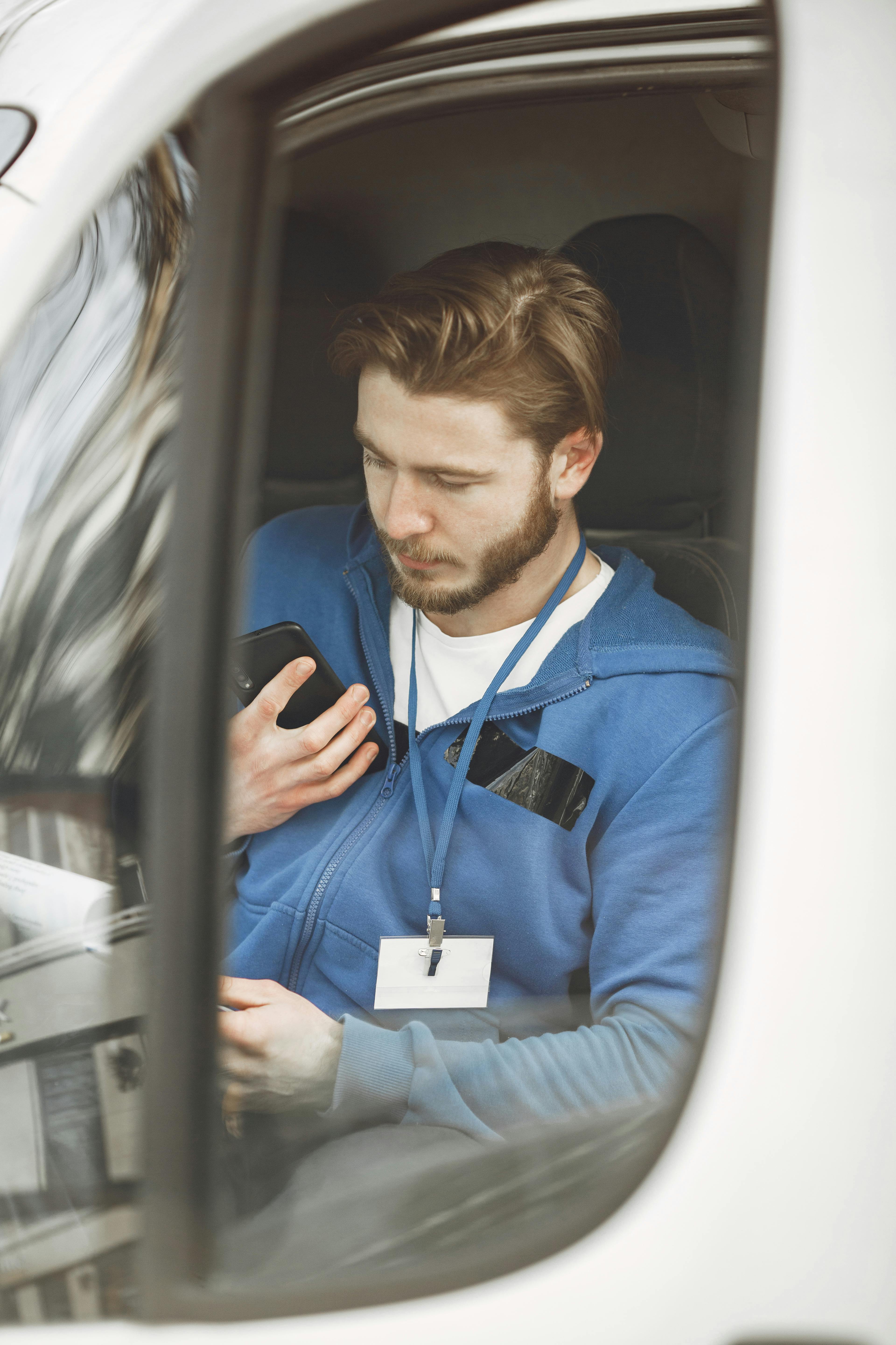 Driver checking route on a phone app beside van