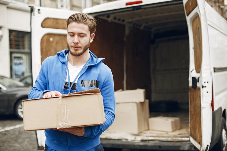 Delivery Man Carrying A Box From A Truck 