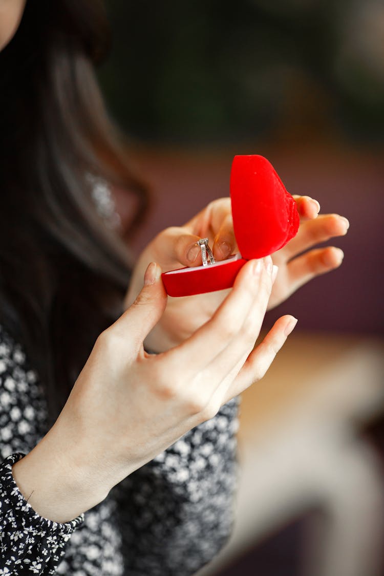 Close-up Of Woman Opening Box With Engagement Ring