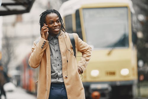 Kostenloses Stock Foto zu afroamerikanischer mann, am telefon sprechen, braunen mantel