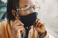 Man Wearing Sunglasses Fixing His Facemask