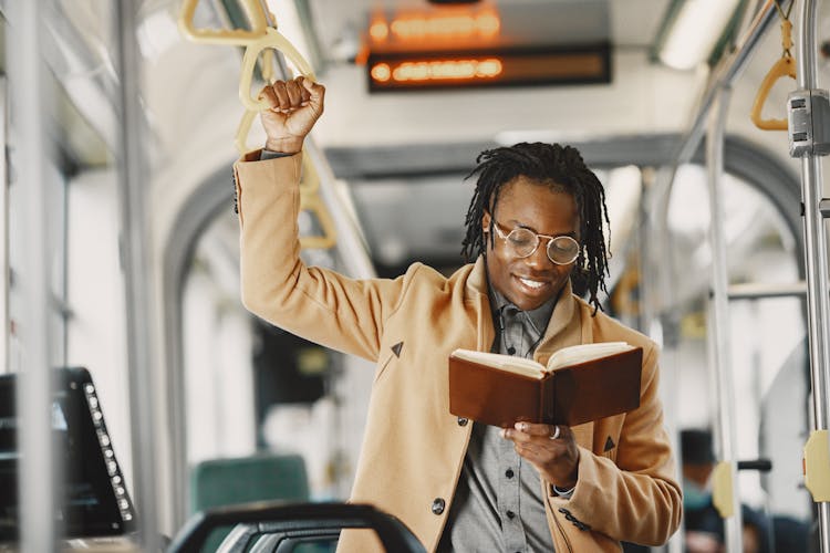 Young Man Reading A Book In A Bus 