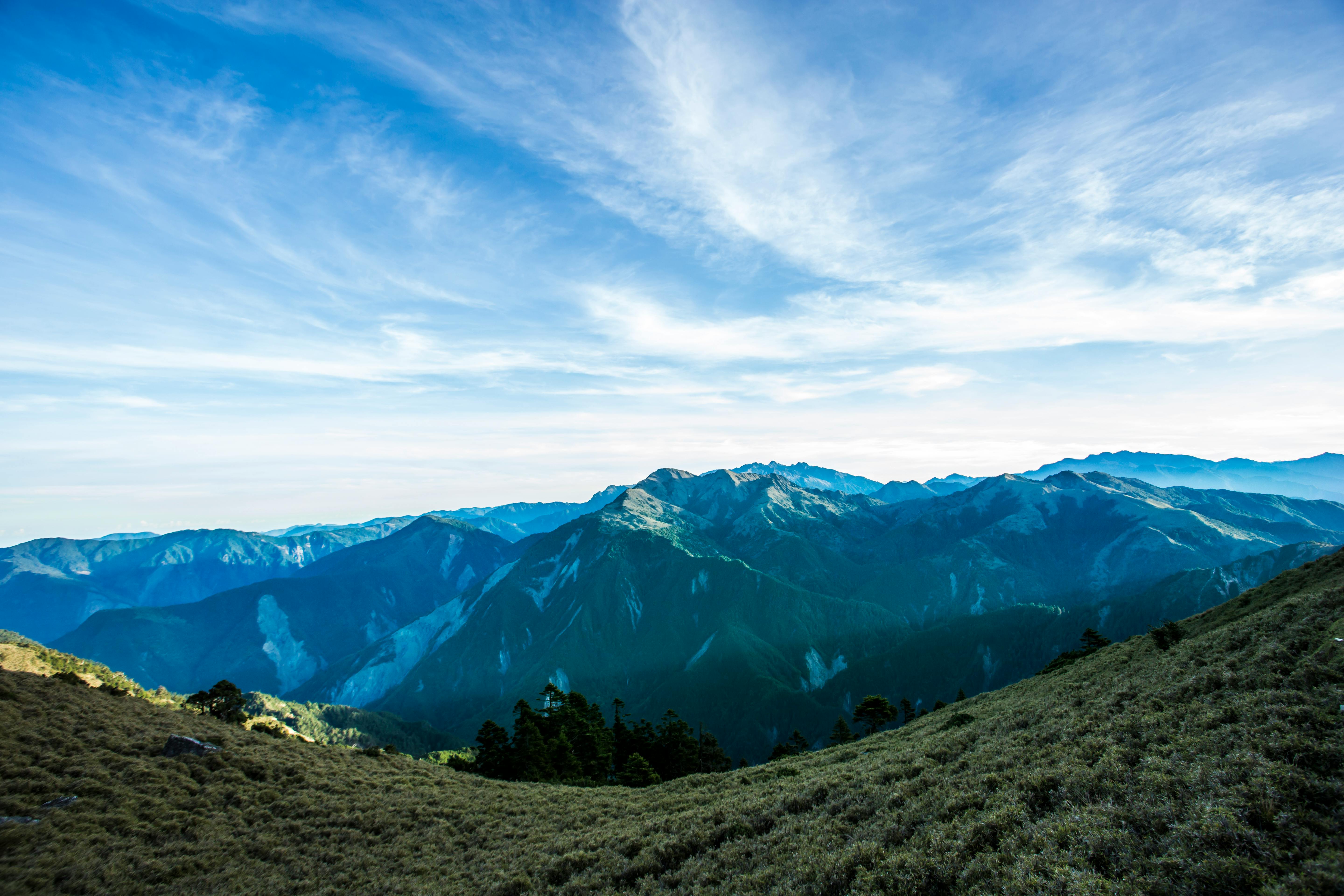 Landscape Photograph Of Mountains Under Blue Cloudy Sky · Free Stock Photo