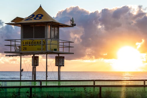 Gratis Foto stok gratis matahari terbenam, menara penjaga pantai, pantai Foto Stok