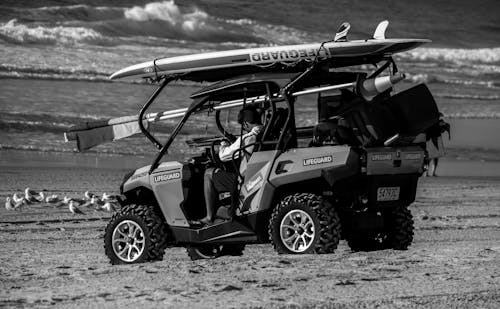 Grayscale Photo of a Lifeguard on an All Terrain Vehicle