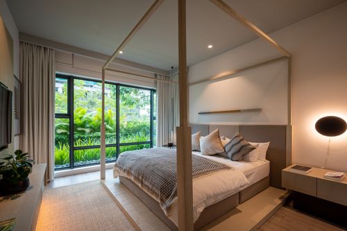 Free A stylish, cozy bedroom with a large window overlooking vibrant greenery. Stock Photo