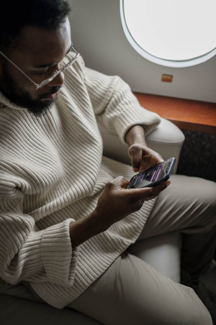 A Man Texting Inside An Airplane