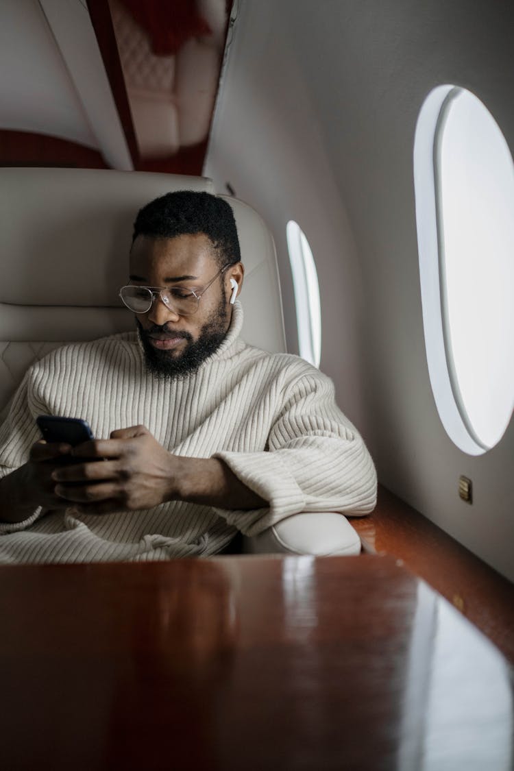 Man In White Sweater Sitting On White Leather Chair