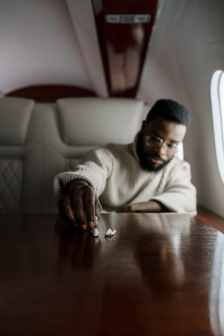 Man Getting His Wireless Earphones On A Table