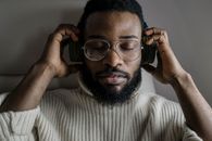 Close-up of a Man Wearing Eyeglasses Listening to Music