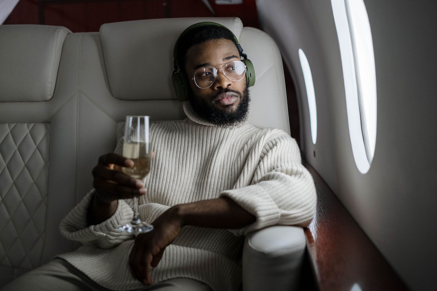 A passenger inside an airplane holding a champagne glass