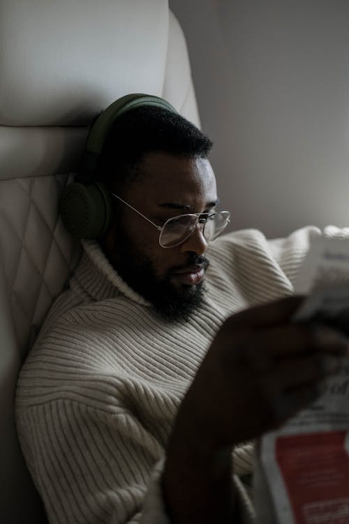 Free Man Reading a Newspaper while in the Airplane Stock Photo