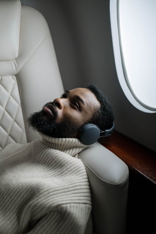 Man in White Sweater Wearing Wireless Headphones