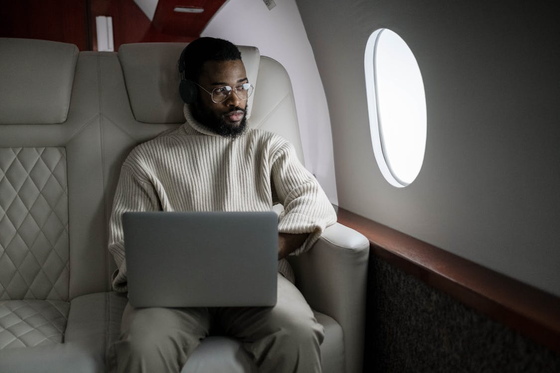 Free Man In White Sweater Sitting On Couch Using Macbook Stock Photo