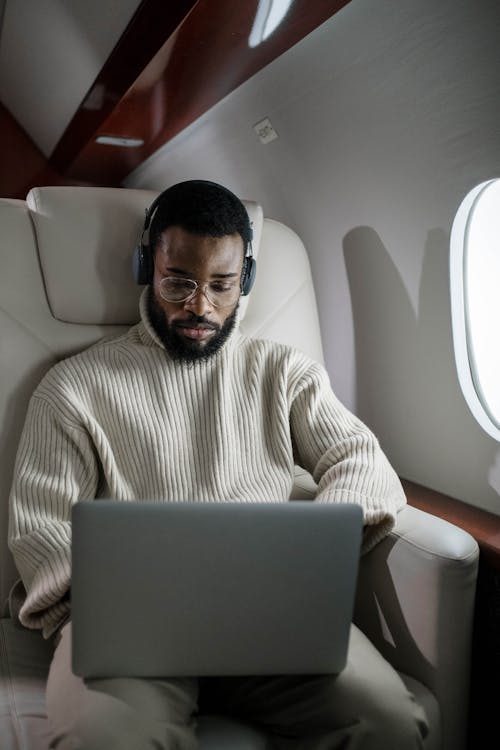 Free Man Using his Laptop While Inside an Airplane Stock Photo