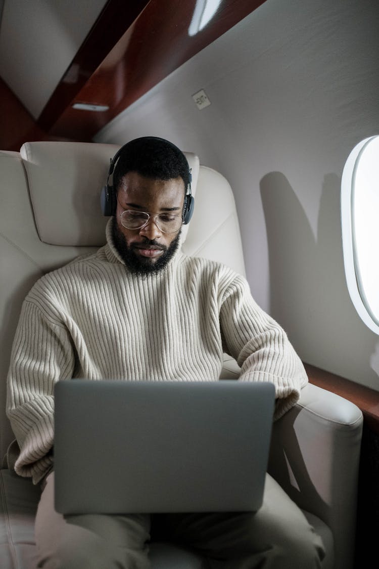 Man Using His Laptop While Inside An Airplane