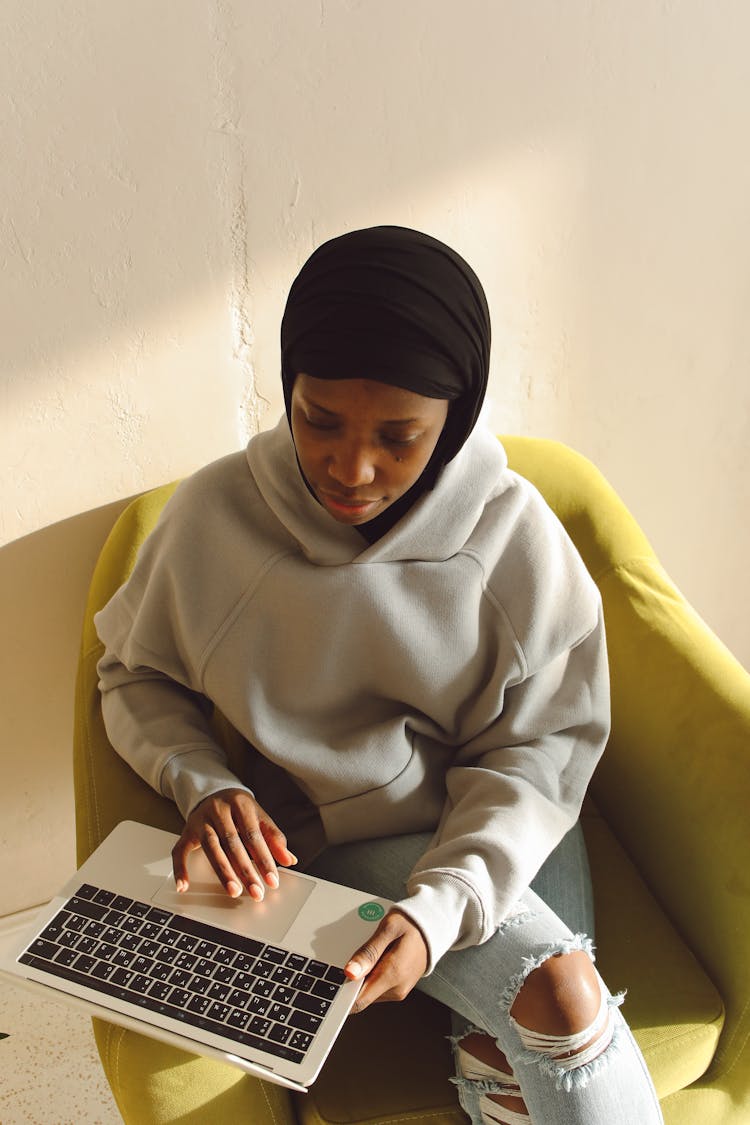 A Woman Wearing Black Hijab Using A Laptop