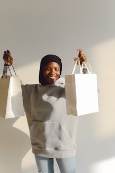 Smiling woman holding shopping bags in a bright indoor space, dressed casually.
