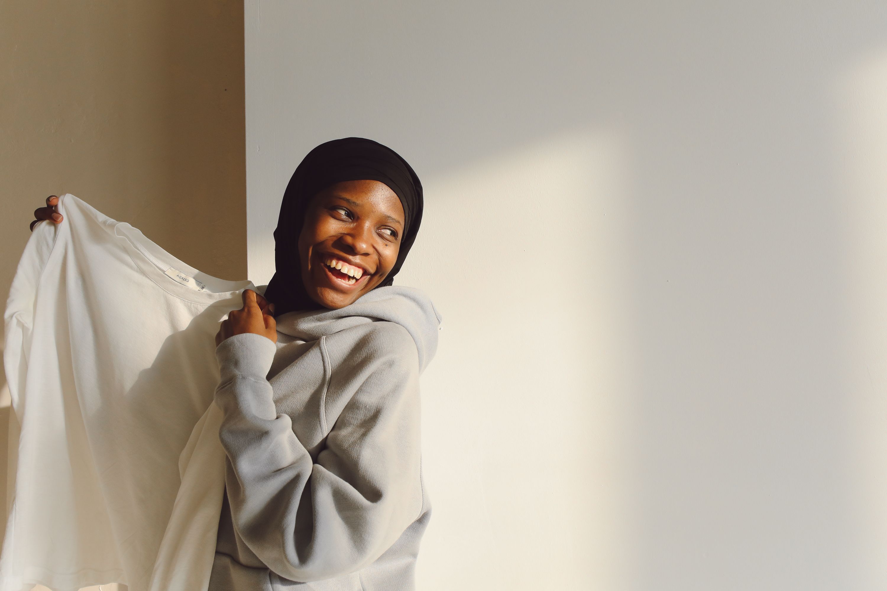 woman in cozy socks and hoodie smiling while walking on a walking pad at home, soft lighting
