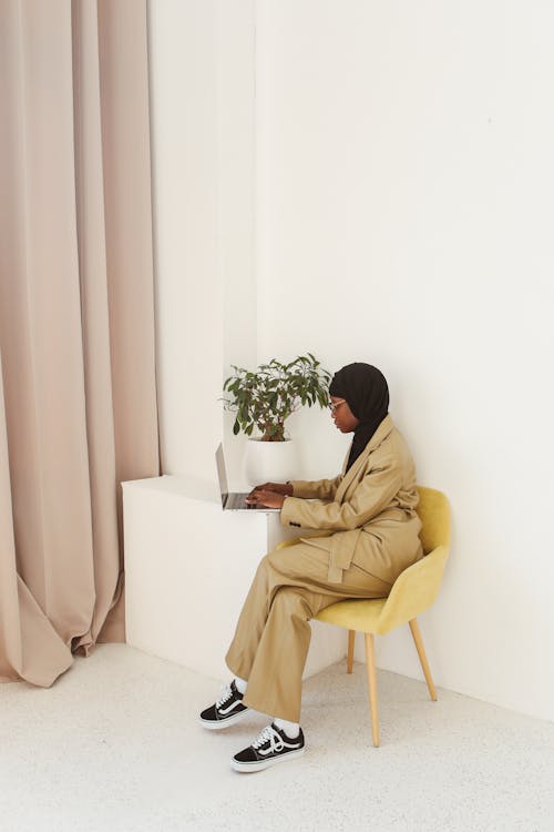 Woman Sitting on Chair While Using a Laptop