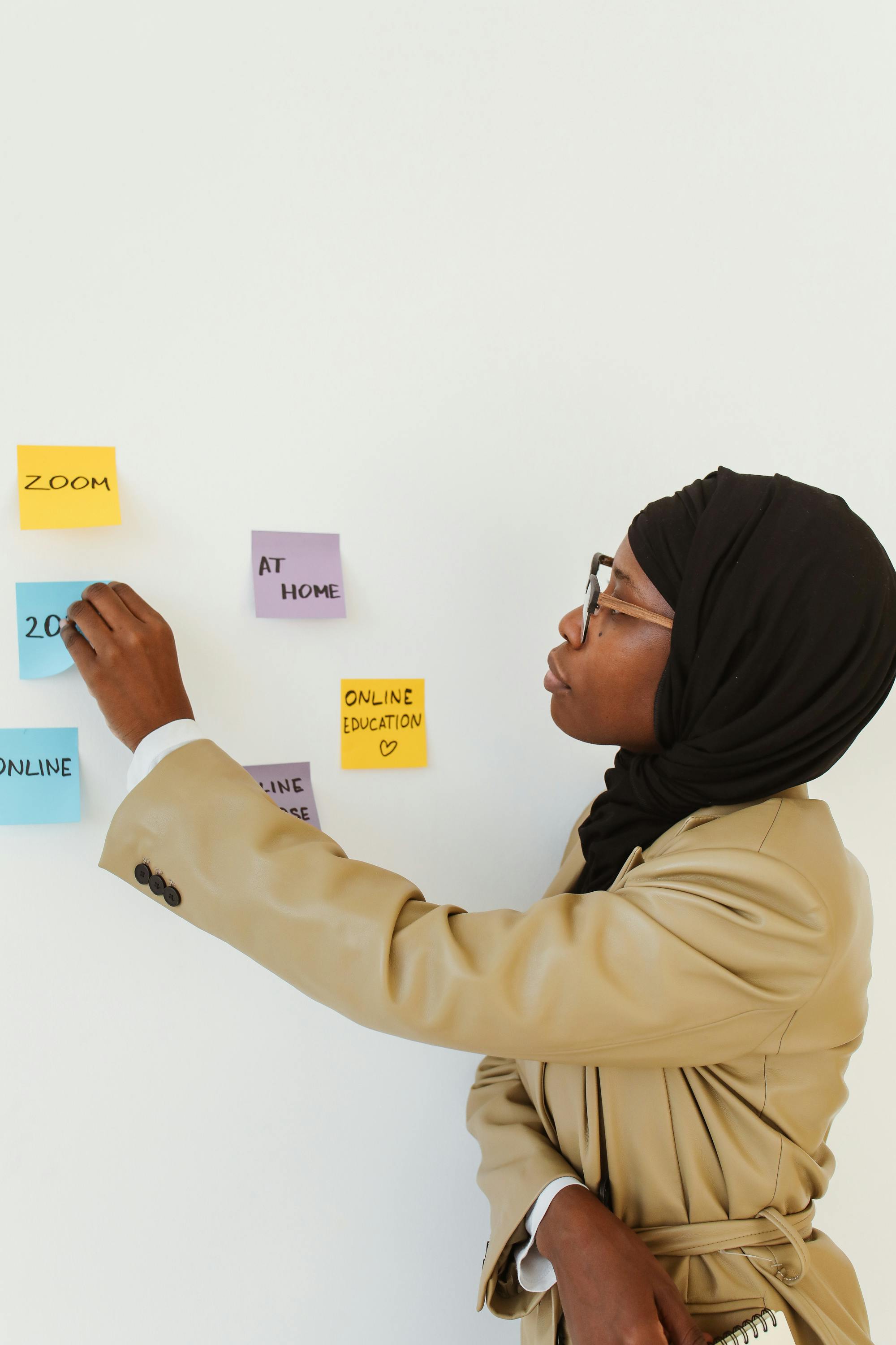 woman looking at sticky notes on white wall