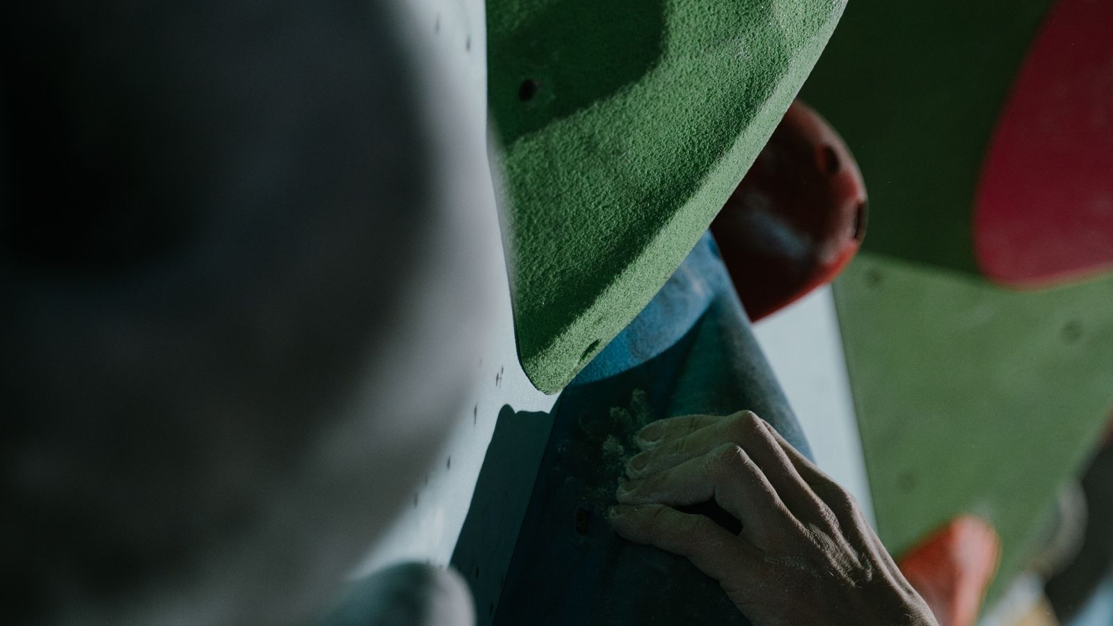 A close-up of a climber's hands and chalk