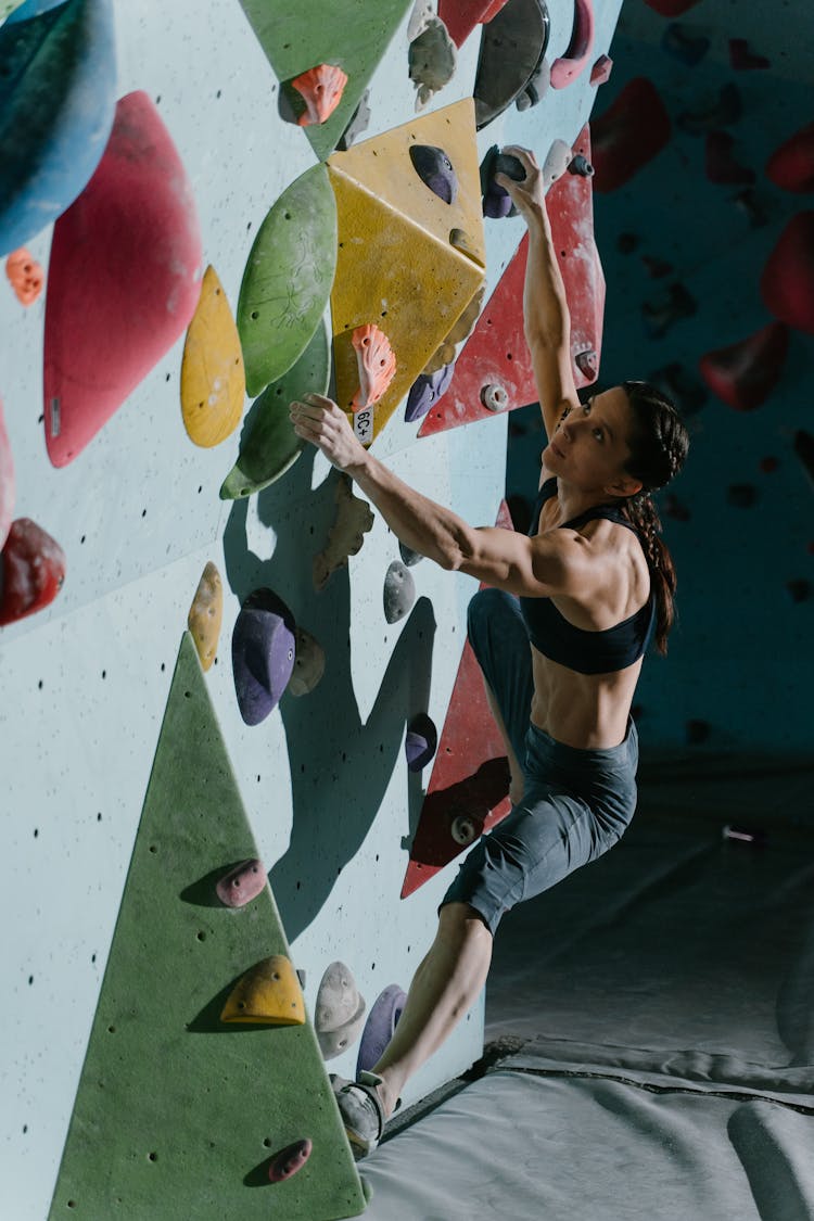 A Woman Climbing A Bouldering Wall