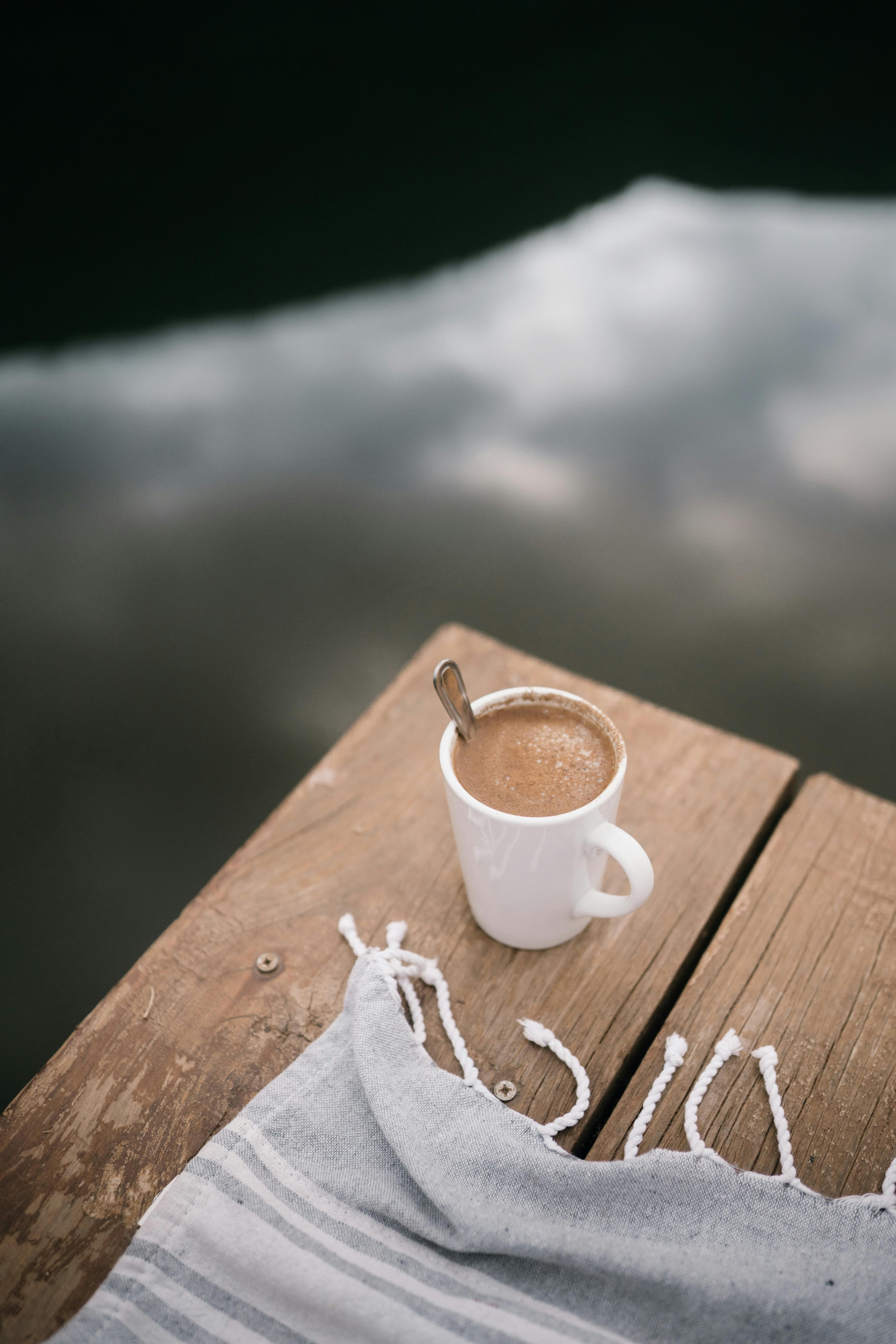 a cup of hot drink over wood