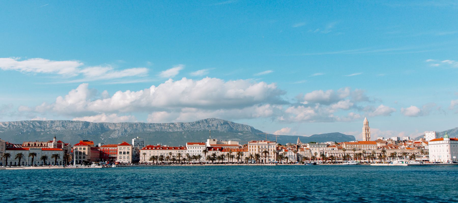 Discover the picturesque coastal cityscape of Split, Croatia, with its charming harbor and mountain backdrop.