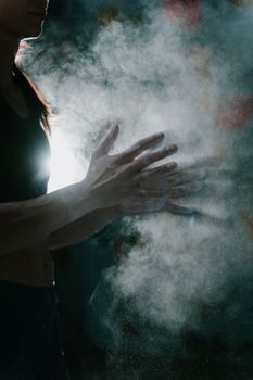Captivating image of hands clapping, creating a cloud of chalk dust with dramatic lighting.