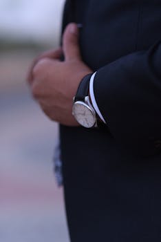 Close-up view of a man's hand wearing a classic wristwatch, showcasing elegance.