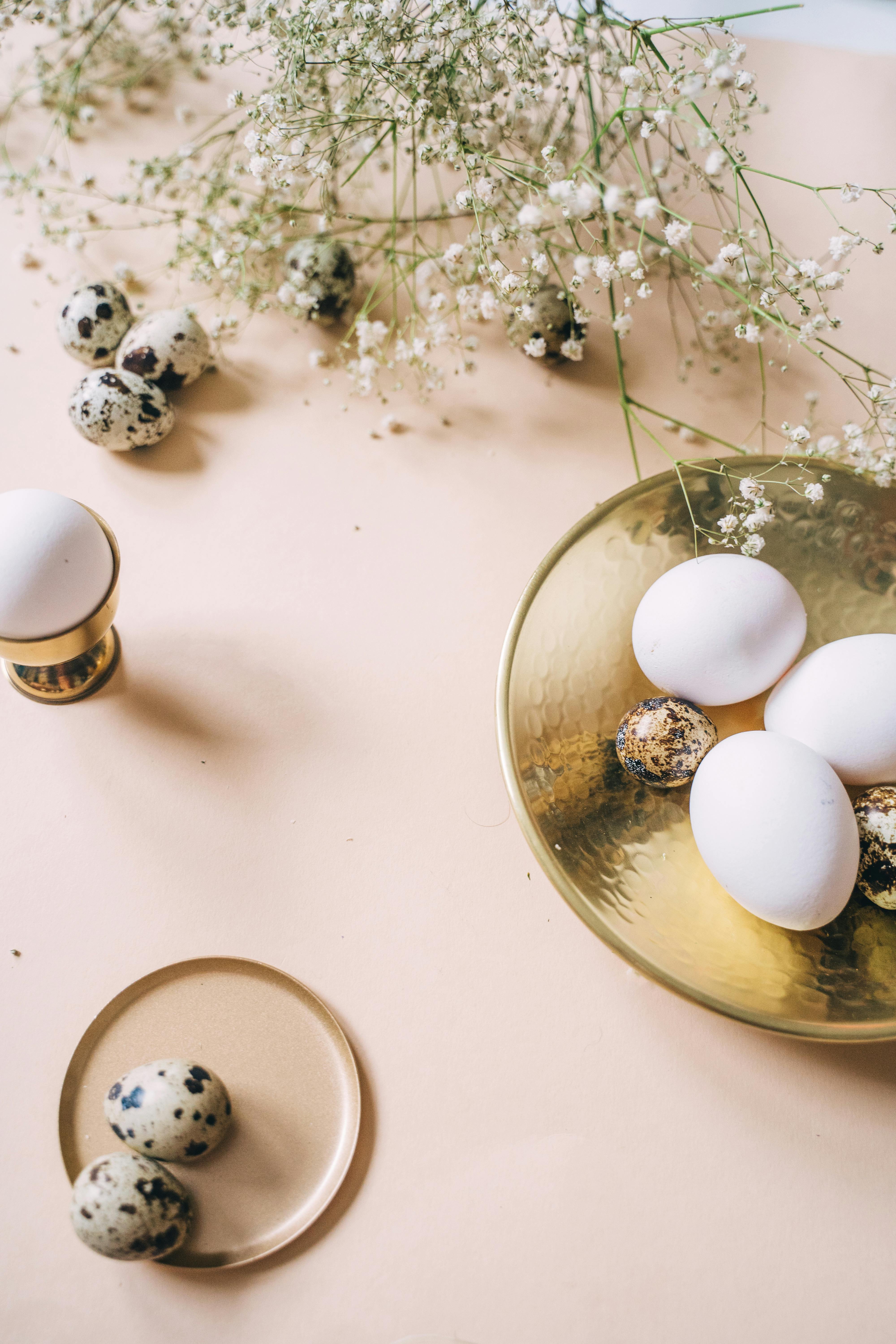 A beautifully arranged still life of Easter eggs with delicate flowers.