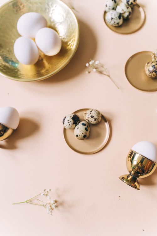 Free Aesthetic Easter egg arrangement with quail and white eggs on stylish brass dishes. Stock Photo