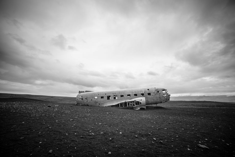 Black and white image of a wrecked airplane on a desolate Icelandic landscape.
