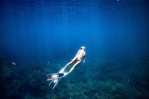 Anonymous lady enjoying snorkeling in blue sea