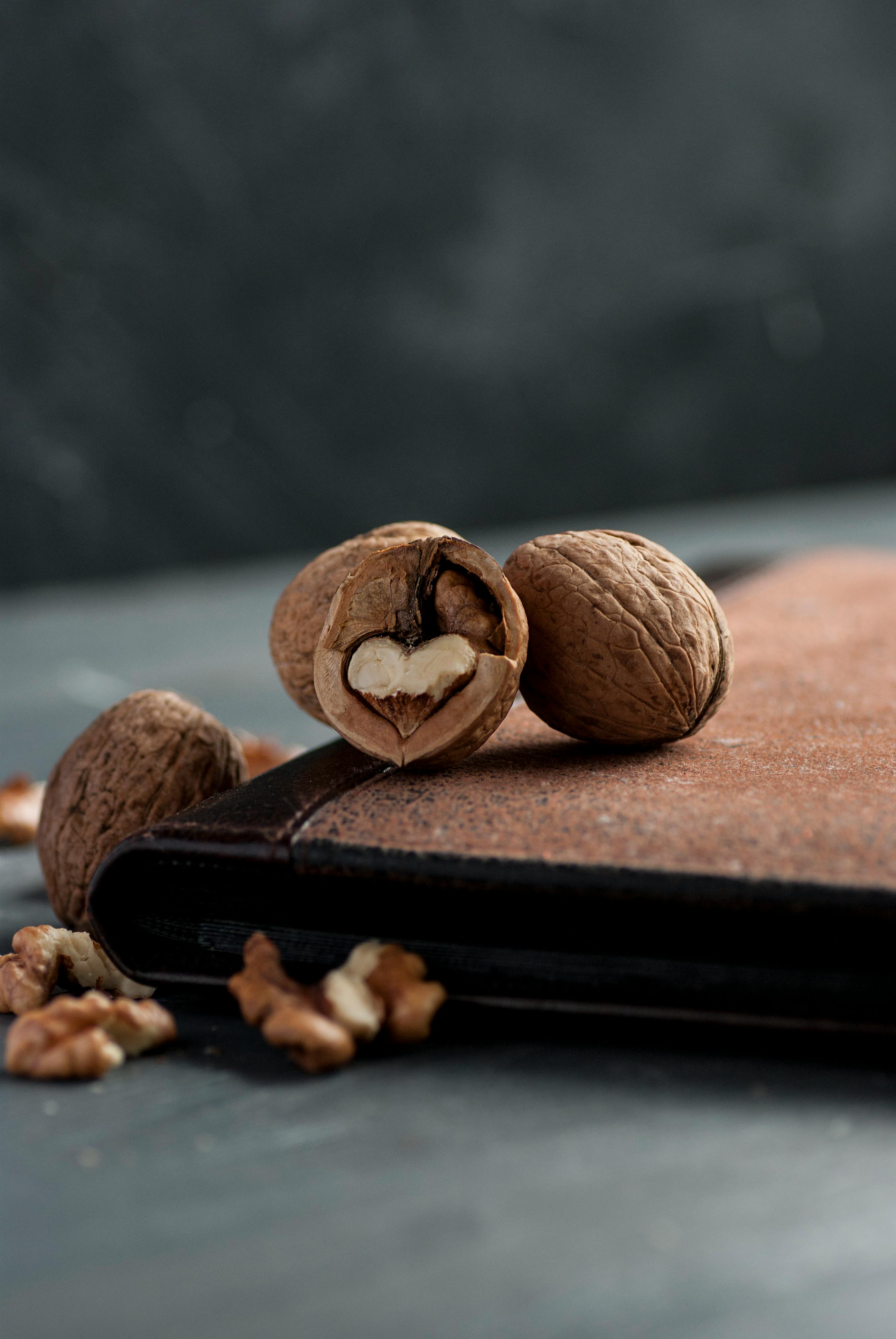 Artistic still life of walnuts on wooden surface showcasing a heart shape.