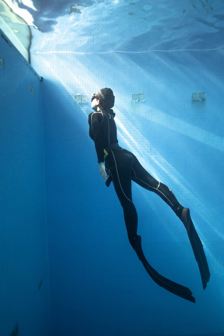 Faceless Woman Diving Underwater In Pool