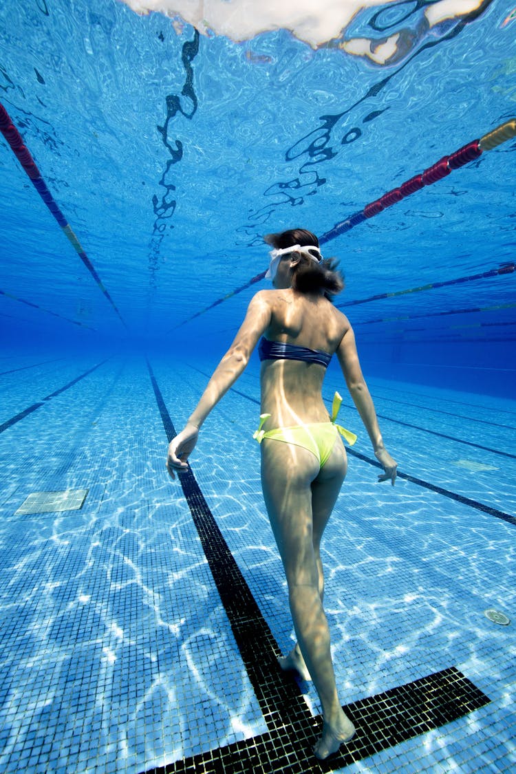 Slim Female Standing Underwater In Pool